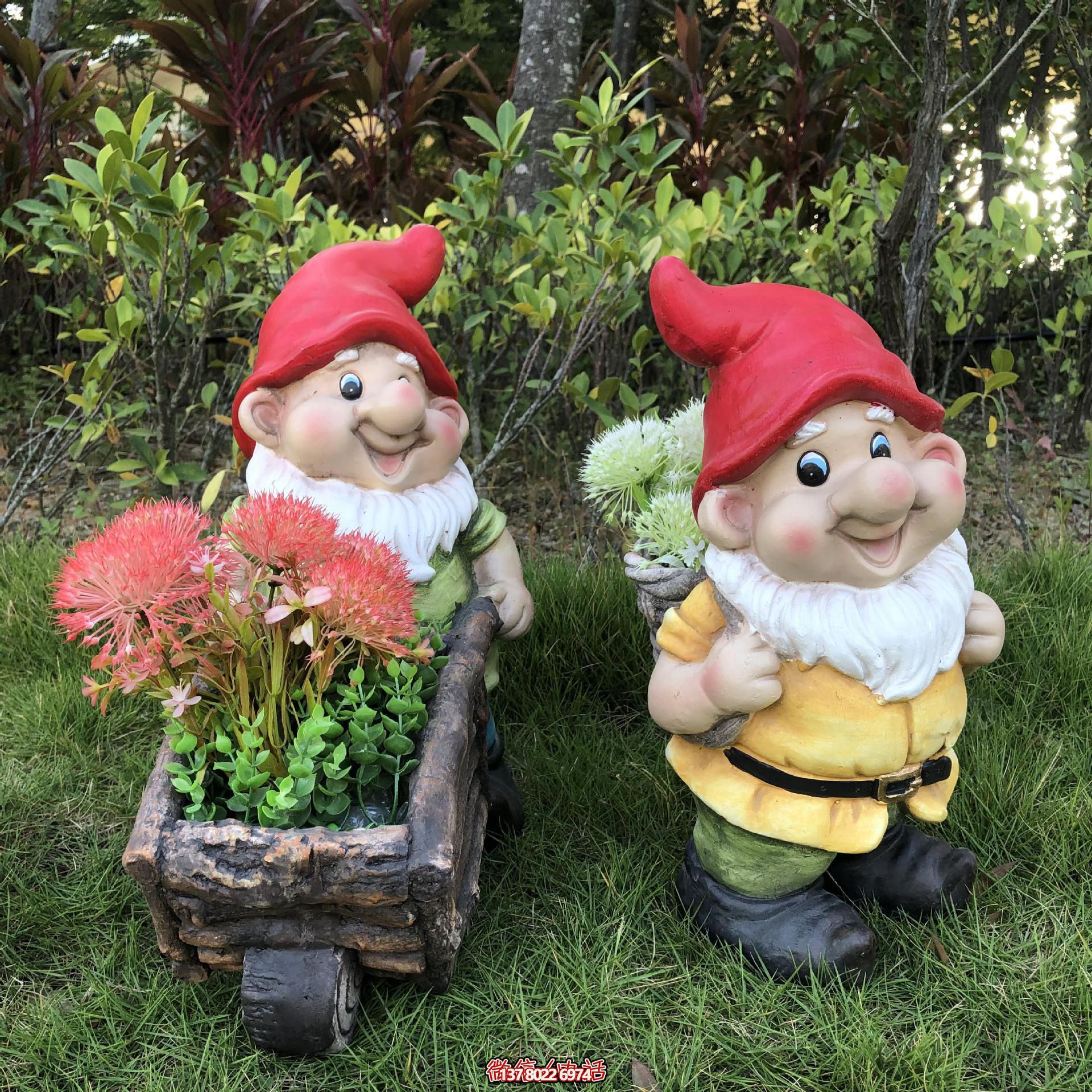 公园里摆放的一只手推花车和一个背筐的玻璃钢卡通蓝精灵雕塑