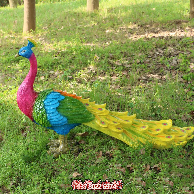 草地上拖着尾巴的玻璃钢彩绘孔雀雕塑