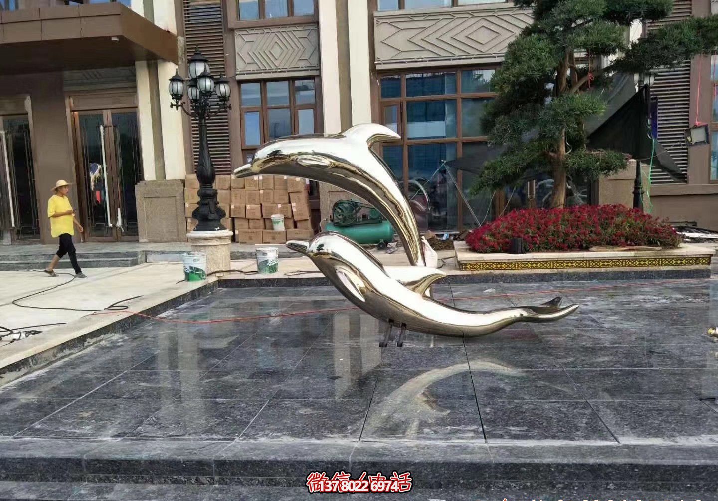 小河边两只镜面不锈钢海豚雕塑