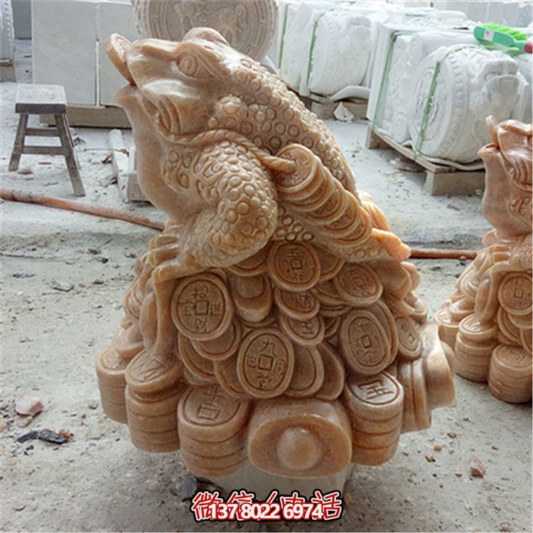 公园里摆放的叼着一串铜钱的晚霞红石雕创意金蟾雕塑