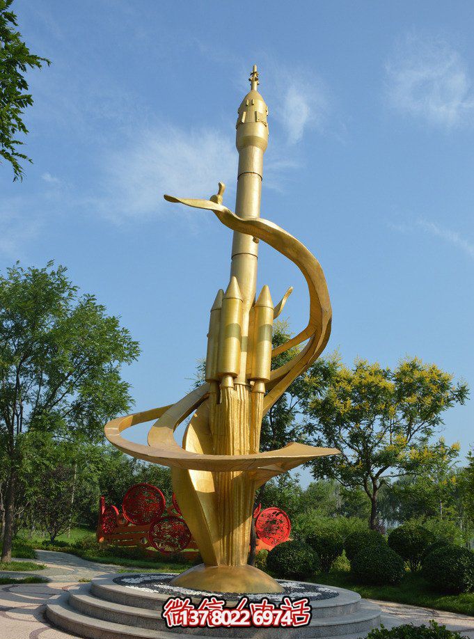 公园里摆放的金色的不锈钢喷漆火箭雕塑